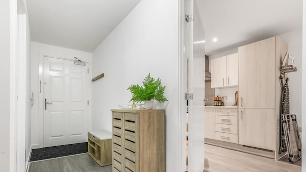 A modern kitchen with white cabinets and a wooden countertop. - Harmony 5 Mins to City Centre Balcony Fast Wifi (Coventry)