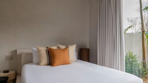 Ein Hotelzimmer mit einem großen Bett, einem Nachttisch und Blick auf Grünflächen.