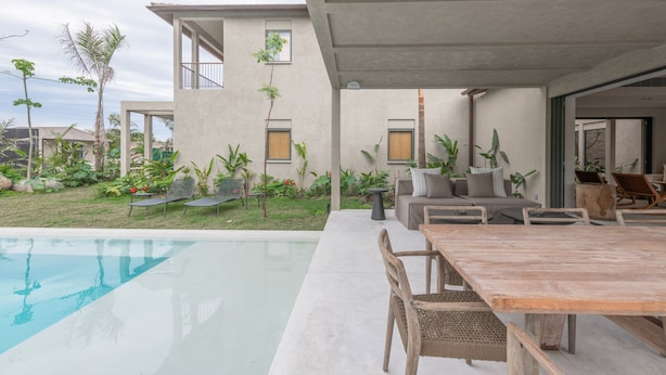 Eine moderne Außenpatio mit Pool, Sitzgelegenheit und Esstisch.