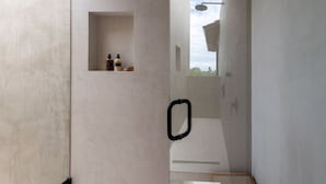 Ein modernes Badezimmer mit Dusche, Handtuchhalter und einer kleinen Ablage für Toilettenartikel.