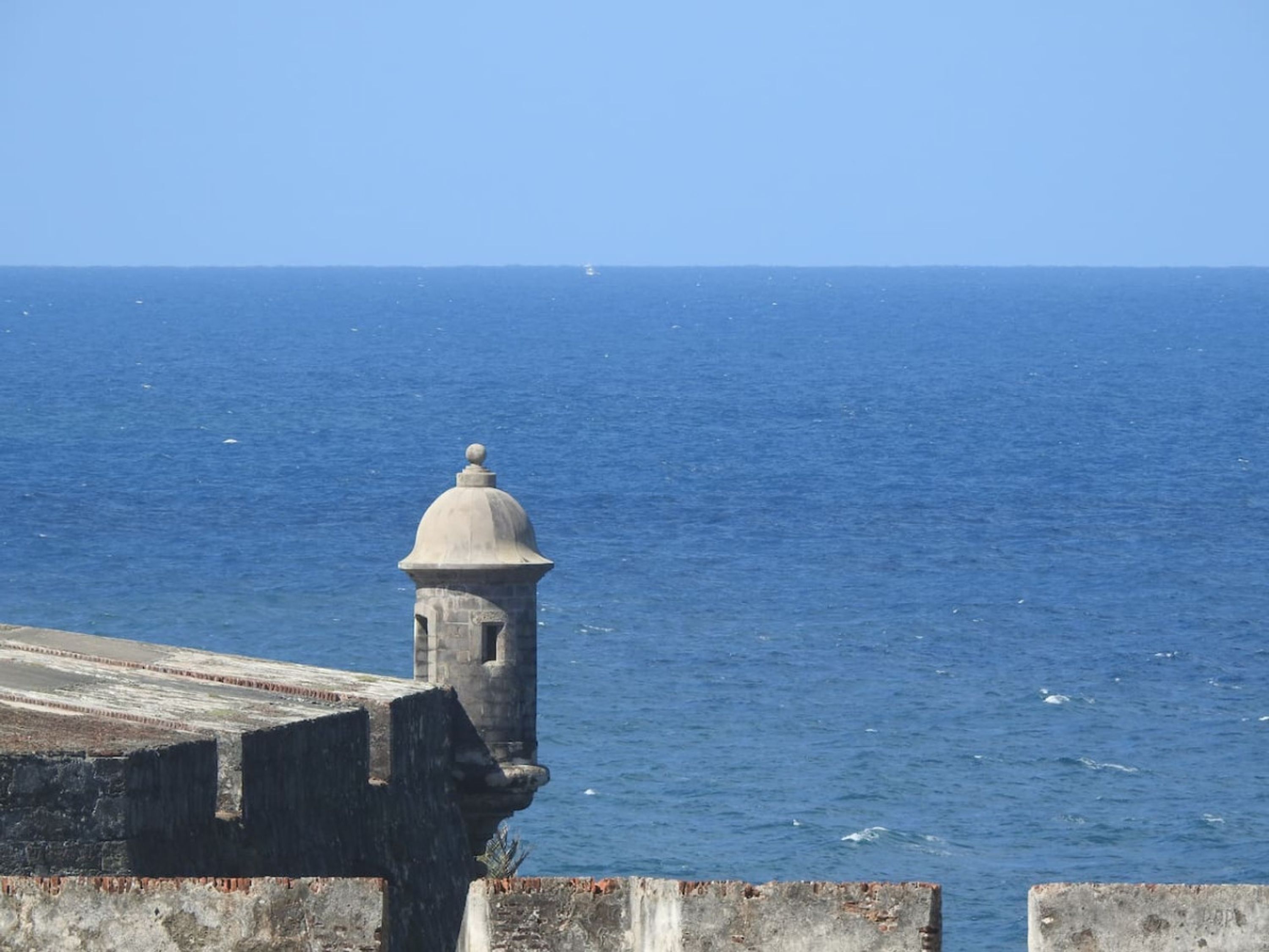 A coastal fortification with a domed tower overlooking the sea.
