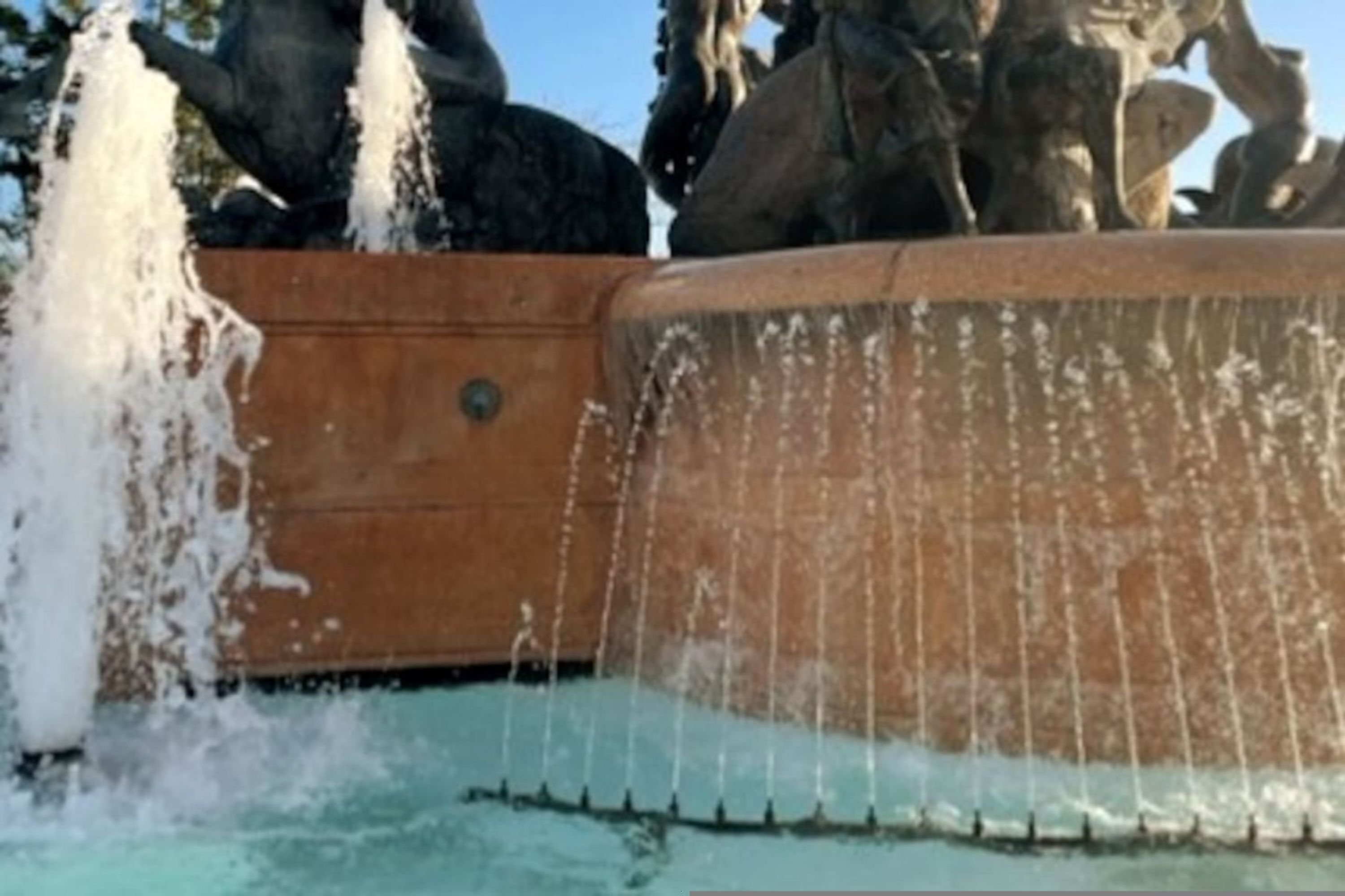 A fountain with water jets and a stone structure.