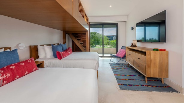 A modern hotel room with two beds, a wooden wardrobe, a large TV, and a view of the outdoors. - Villa Amistad in Punta Mita (Punta de Mita)