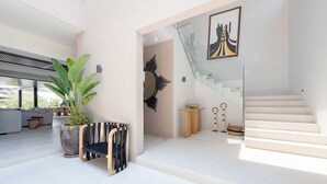 A modern interior with a staircase, a large potted plant, and a minimalist design. - Villa Amistad in Punta Mita (Punta de Mita)