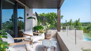 A modern outdoor seating area with a pool, large windows, and potted plants. - Villa Amistad in Punta Mita (Punta de Mita)