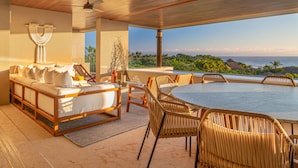 A spacious outdoor seating area with a wooden ceiling, a round table, and wicker chairs. - Condo Haramara in Punta Mita (Punta de Mita)