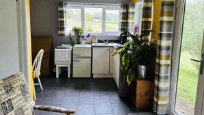 A compact kitchen with a window, a sink, and a refrigerator. - The Cabin in Lifton With 1 Bedrooms and 1 Bathrooms (Lifton)