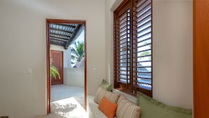 A hallway with a wooden bench, a door leading outside, and a window with wooden blinds. - Casa Caracol - Mita Residential Farallon (Punta de Mita)