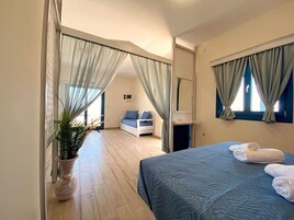 Un dormitorio con cama, mesita de noche, espejo y planta en maceta.