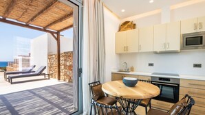 A modern kitchen with a round table, chairs, and a built-in oven. - Isanema Villa 2 in Karpathos (Karpathos)