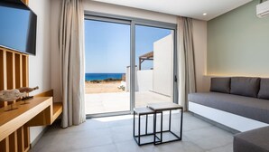 A modern living room with a large sliding glass door leading to a balcony with a view of the beach. - Isanema Villa 2 in Karpathos (Karpathos)
