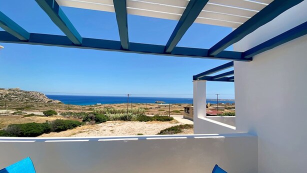 Un balcon avec vue sur la mer et un ciel dégagé.