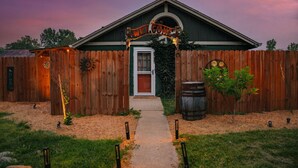 A wooden house with a 'WELCOME' sign, a front door, and a pathway leading to it.