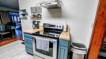 Una cocina compacta equipada con estufa, horno y cafetera.