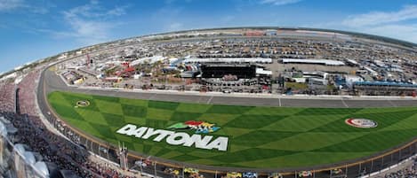 A large stadium with a green racing track and the word "DAYTONA" on the field.