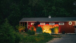Un edificio con un mural que da la bienvenida a visitantes a Ruby Ranch, rodeado de un bosque denso.