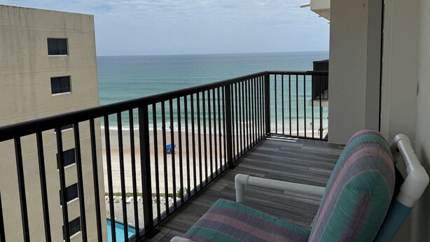 Ein Balkon mit Blick auf Strand und Meer.