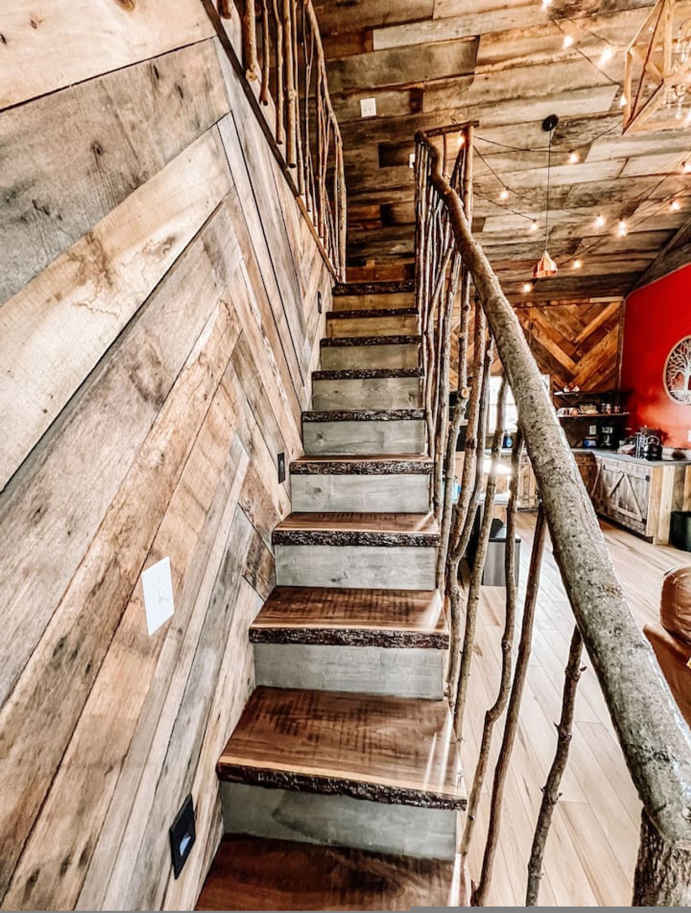 A wooden staircase with a metal railing, surrounded by wooden walls and beams.
