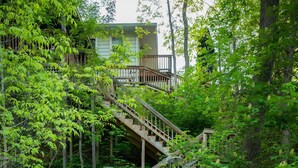 A wooden staircase leading to a dock with kayaks and a boat. - Lakefront-nestled in Nirvana (Martinsville)