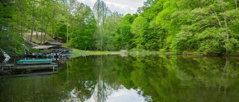 A serene lakeside setting with a dock and a small cabin.