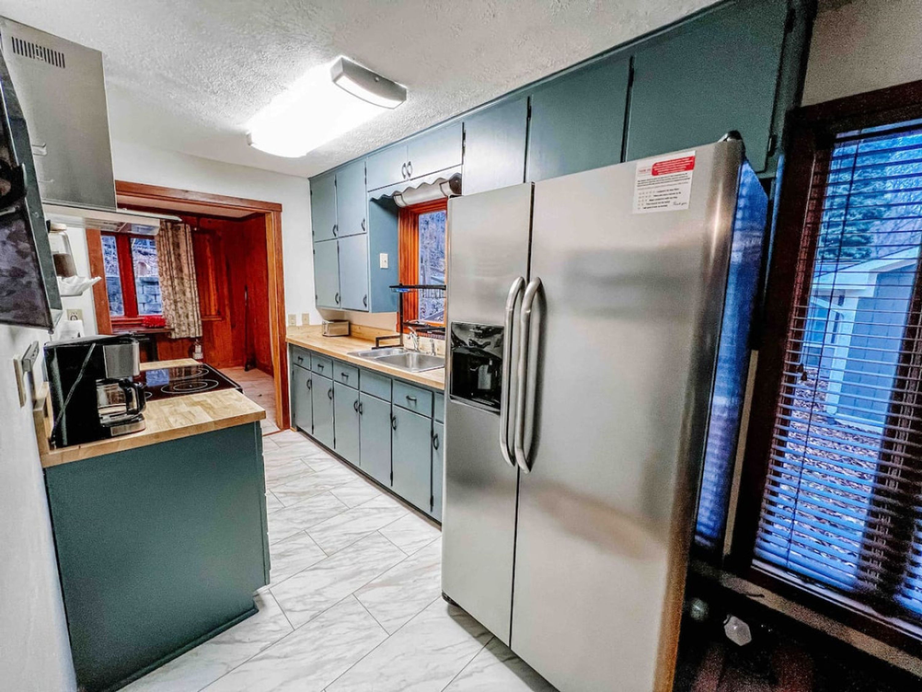 Una cocina compacta con un refrigerador, una estufa y un lavamanos.