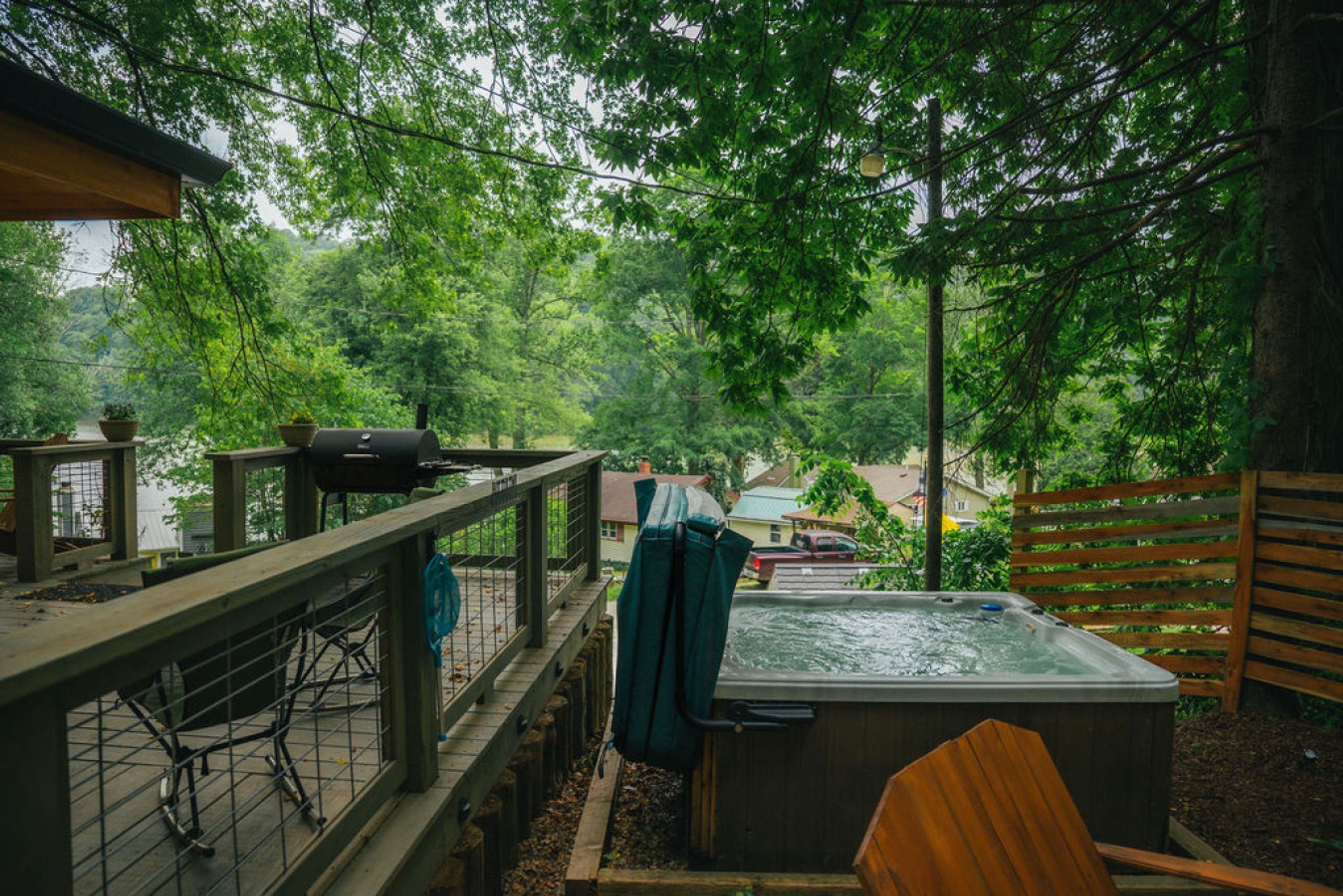 A hot tub and deck area with a view of a residential neighborhood.