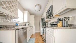 A modern kitchen with white cabinets, stainless steel appliances, and a granite countertop. - Convenient to Ole Miss The Square (Oxford)