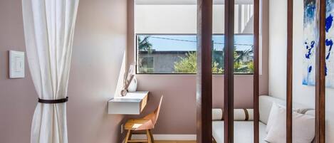 A modern bedroom with a bed, a desk, and a chair.