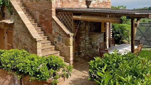 A stone building with a wooden staircase leading to a covered patio area. - Agriturismo Borgo 7 Tigli Apt 2 (Montepulciano)