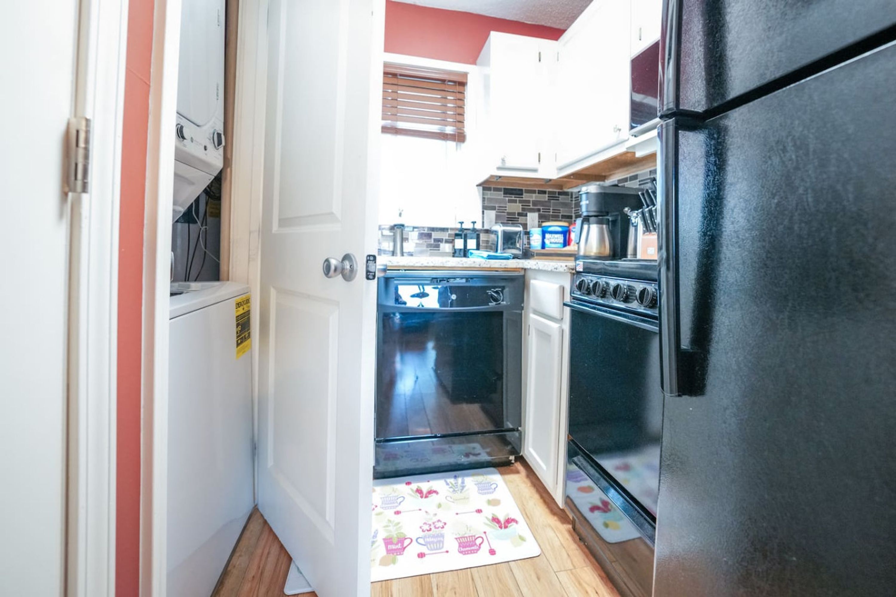 A compact kitchen with a refrigerator, oven, and dishwasher.