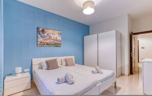 A bedroom with a bed, nightstands, a wardrobe, and a painting on the wall. - St James the Traditional 4-bed Townhouse Terrace (Sliema)