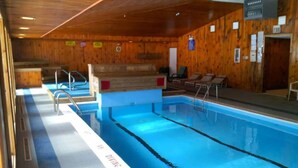 An indoor swimming pool with wooden walls and a diving board. - Top 3rd Floor Loft Resort Access No Elevator (Claysburg)