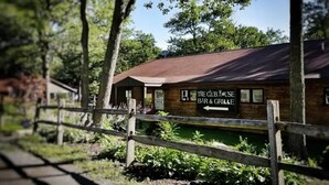 A rustic wooden building labeled "The Club House Bar & Grill" with a sign indicating "Lite" beer. - Top 3rd Floor Loft Resort Access No Elevator (Claysburg)
