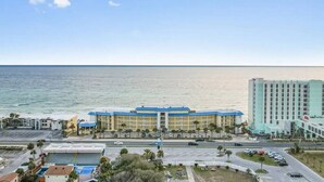 Hotel amb teulada blava, aparcament i vista a l'oceà.