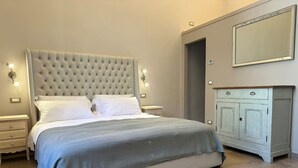 A bedroom with a large bed, a dresser, and a mirror. - Tuscan Palace - Venturi Apartment (Montepulciano)