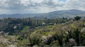 A rural landscape with terraced fields, a few buildings, and a cloudy sky. - Tuscan Palace - Venturi Apartment (Montepulciano)