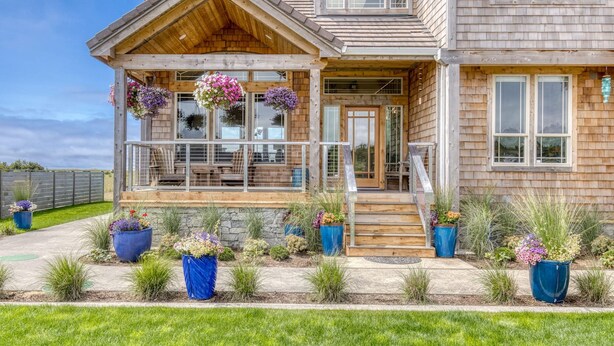 A two-story wooden house with a covered porch and a stone foundation. - Oceanfront Comfort Style Luxury Hot Tub Wifi 600 35 (Long Beach)