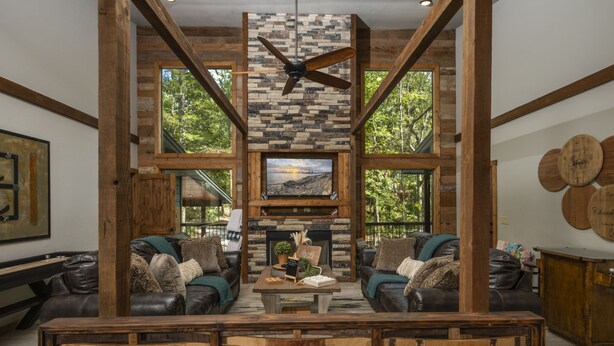 A spacious living room with a fireplace, leather sofas, and a large TV screen. - Wine Time Family Retreat With Heated Pool Hot Tub 4 King Suites Near Broken Bow (Broken Bow)