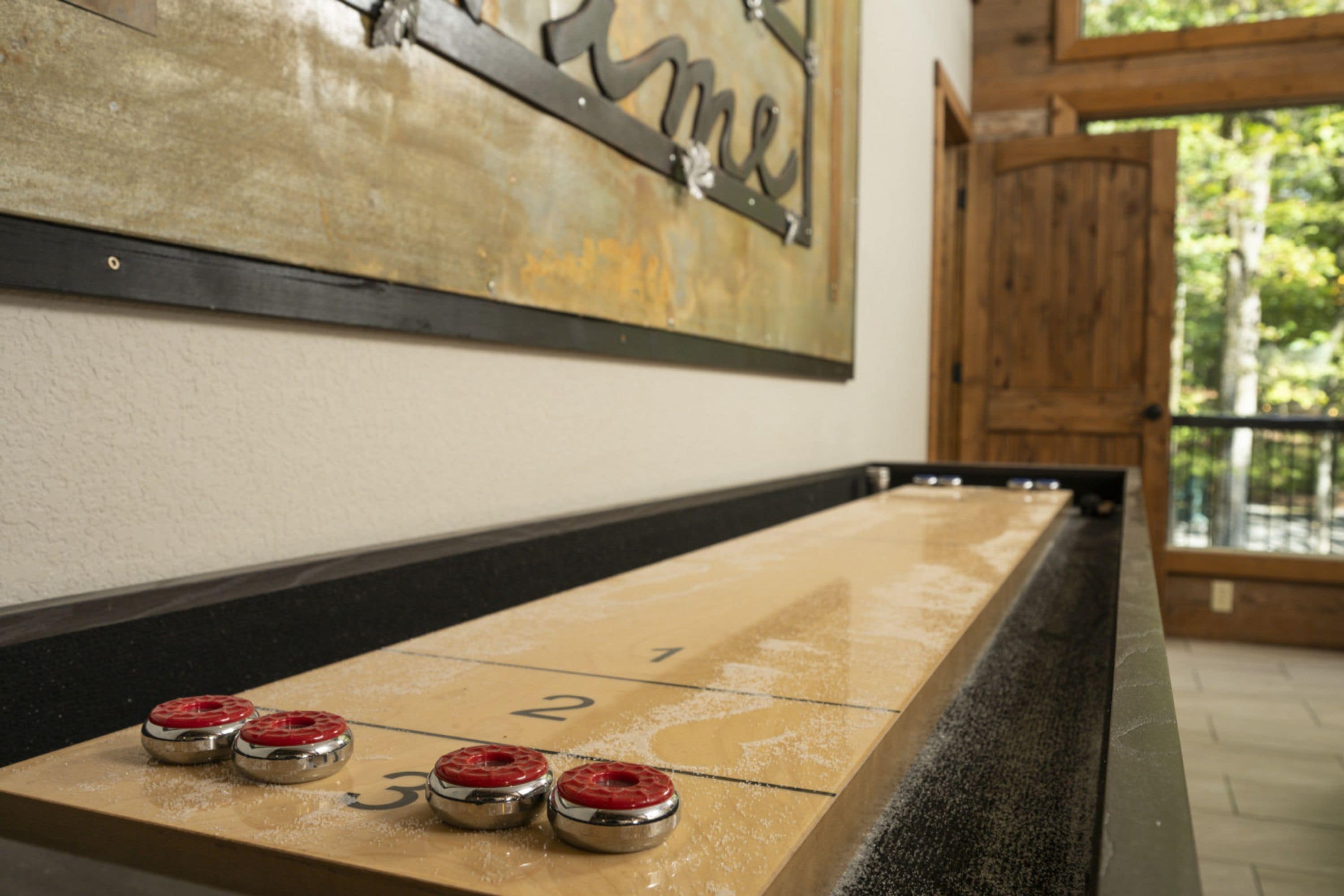 A shuffleboard table with numbered ends and three red-bellied pins.