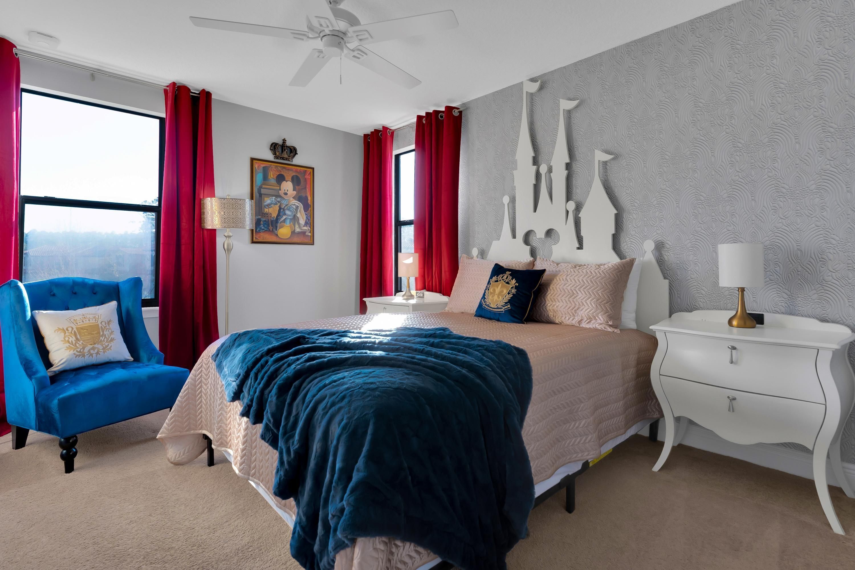 A bedroom with a bed, a nightstand, a chair, and a window with curtains.