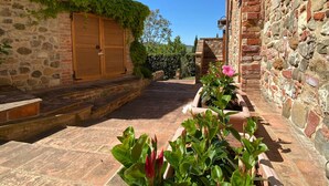 A narrow stone pathway flanked by buildings with ivy-covered walls and wooden shutters. - Agriturismo Borgo Sette Tigli Apt 3 (Montepulciano)