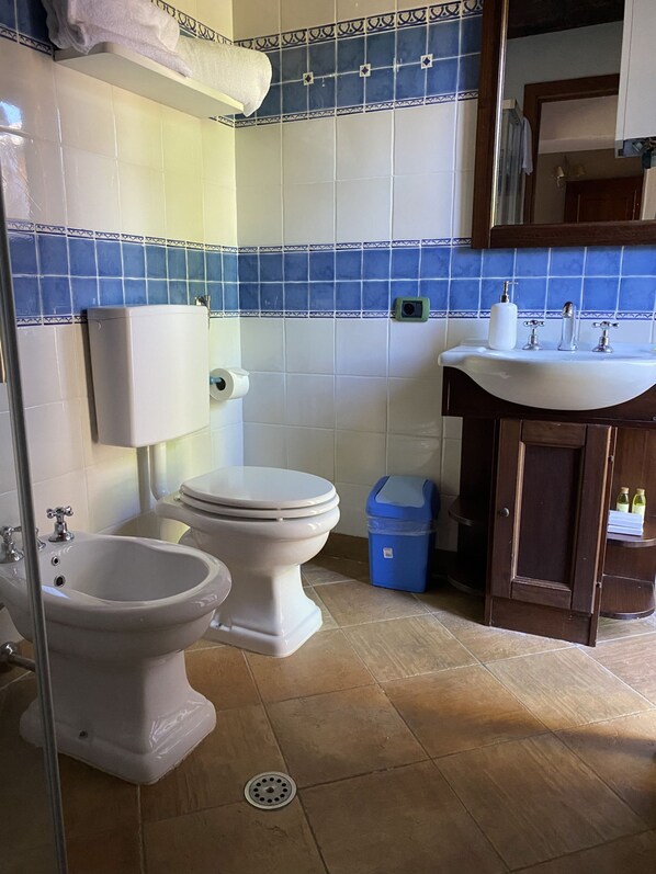 A bathroom with a toilet, bidet, sink, and a trash bin. - Agriturismo Borgo Sette Tigli Apt 3 (Montepulciano)