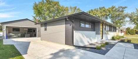A single-story house with a garage, a covered patio, and a well-maintained lawn.