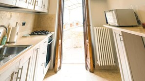 A kitchen with a decorative ceiling, cabinets, a stove, and a view to the outside.