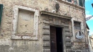 An old building with a wooden door and a small window.