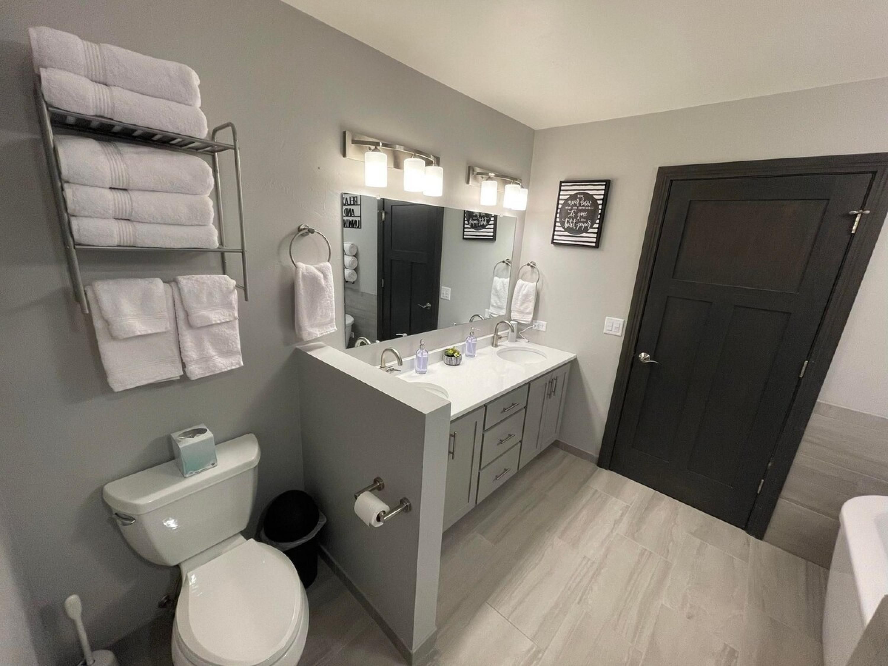 A modern bathroom with a toilet, sink, and towel rack.