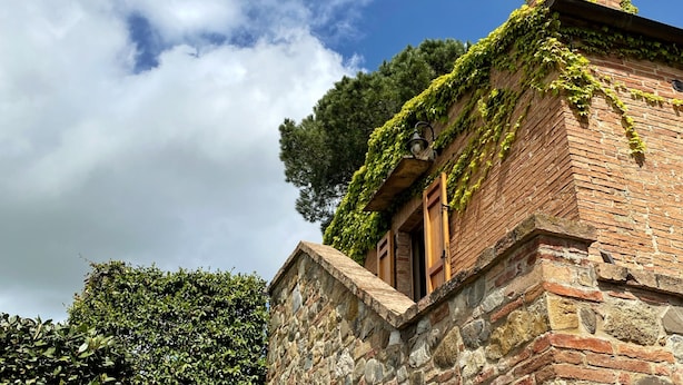A stone building with ivy-covered walls and a wooden door. - Agriturismo Borgo Sette Tigli Apt 5 (Montepulciano)