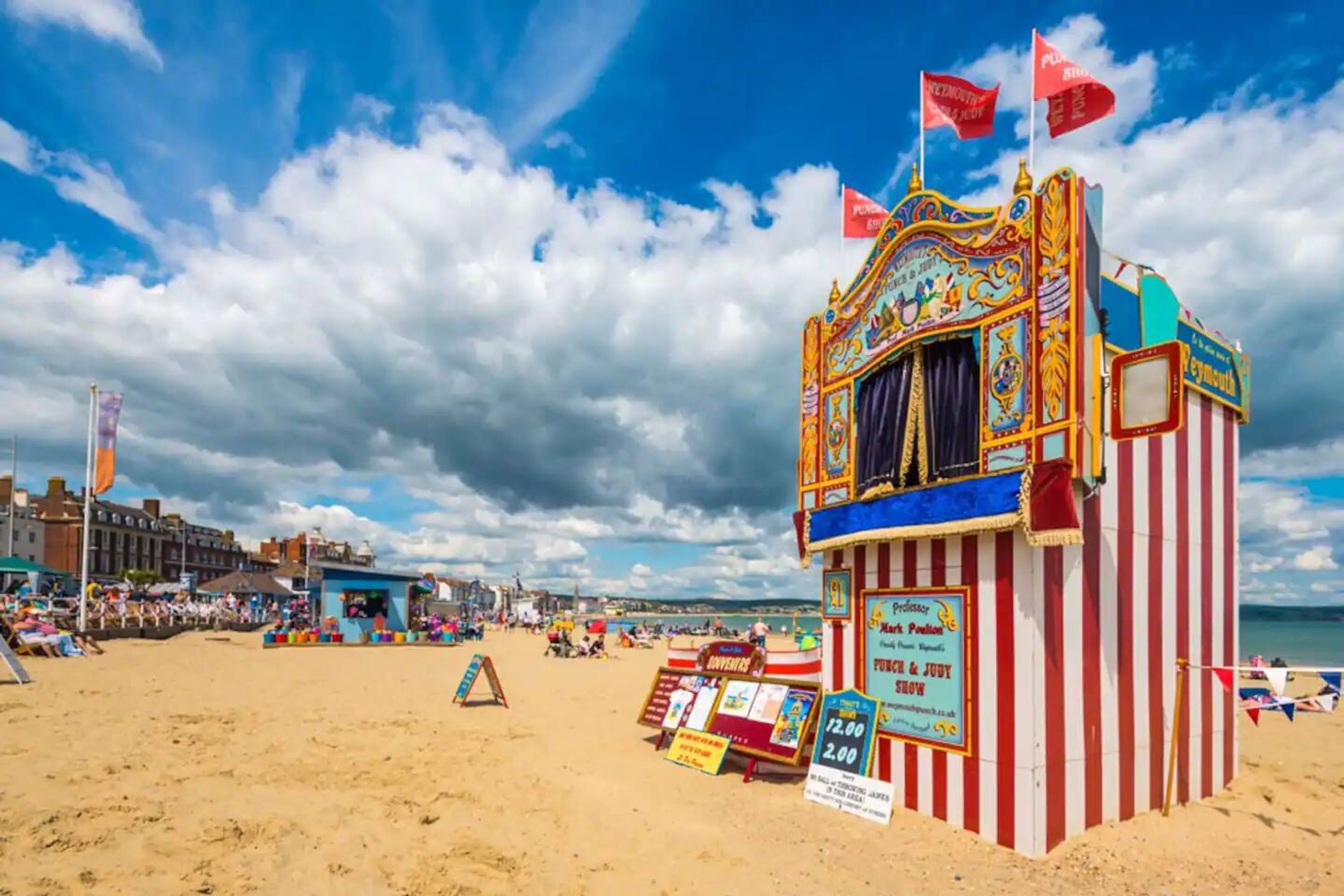 A beachside carnival tent with a sign advertising a show.