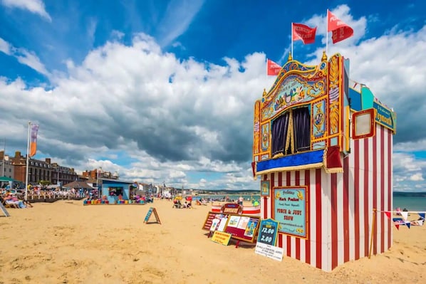 A beachside carnival tent with a sign advertising a show.