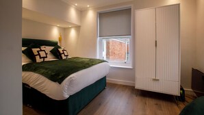 A bedroom with a bed, a wardrobe, a window, and a ceiling light. - Luxury Charming Seaside Flat Weymouth (Weymouth)